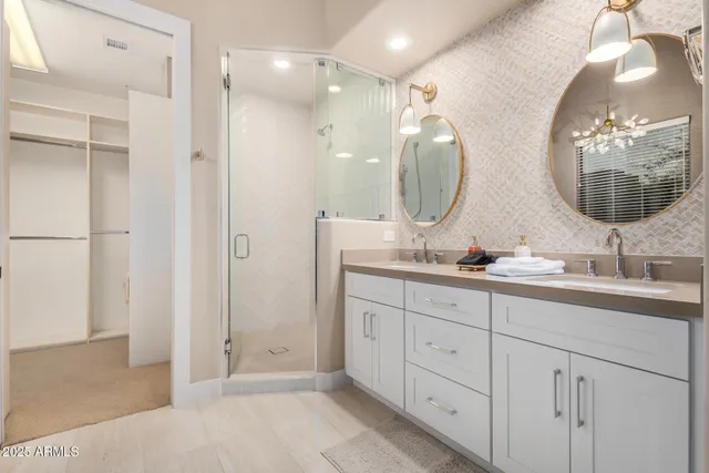 a bathroom with a double vanity sink mirror and shower