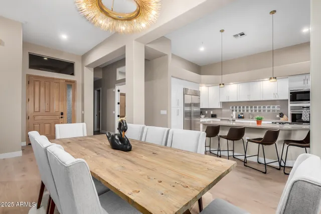 a kitchen with stainless steel appliances kitchen island granite countertop a dining table chairs and view living room