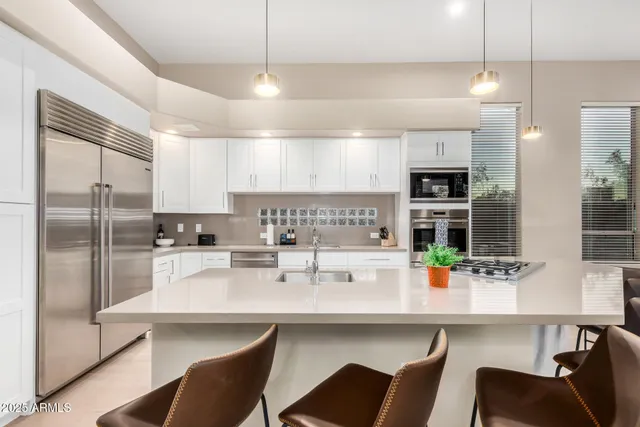 a kitchen with a dining table chairs and refrigerator