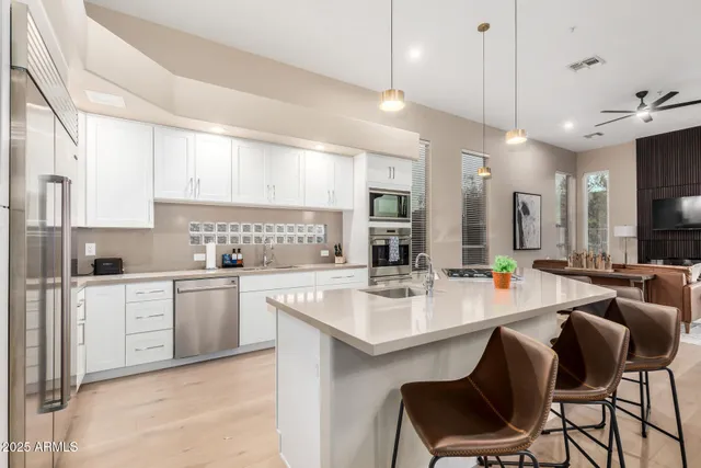 a kitchen with appliances a sink cabinets and wooden floor