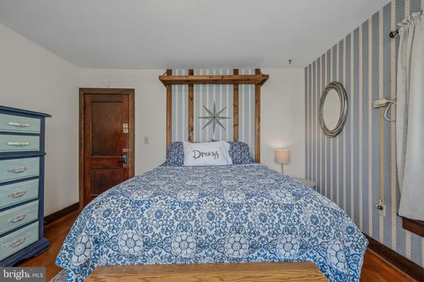 a bedroom with a bed and dresser with mirror