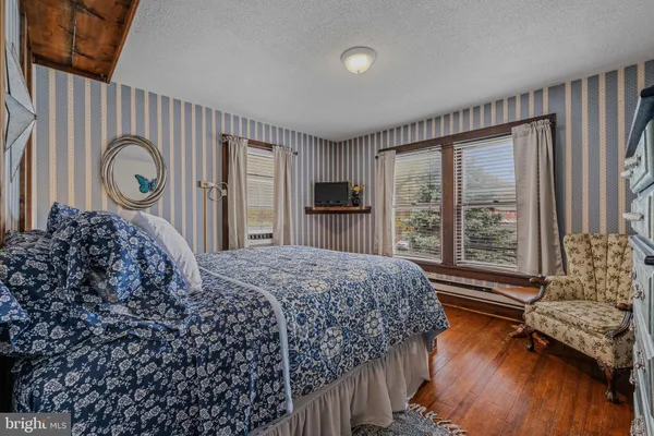 a bed sitting in a spacious bedroom next to a window