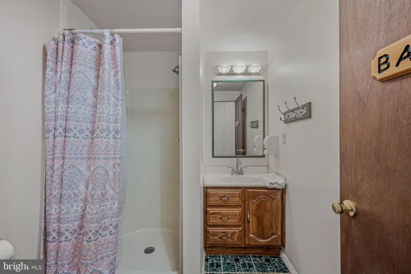 a bathroom with a granite countertop shower a sink and a mirror