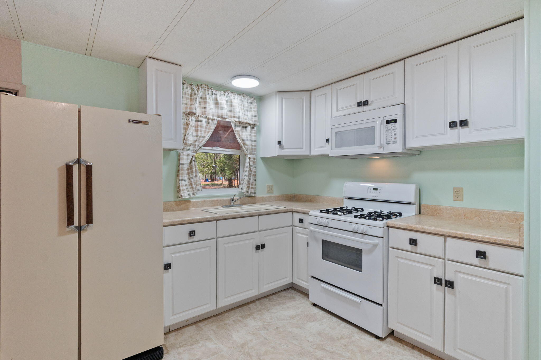 7517 Brett Road Shingletown, CA 96088 - Photo 5 of 26 a kitchen with white cabinets and white appliances