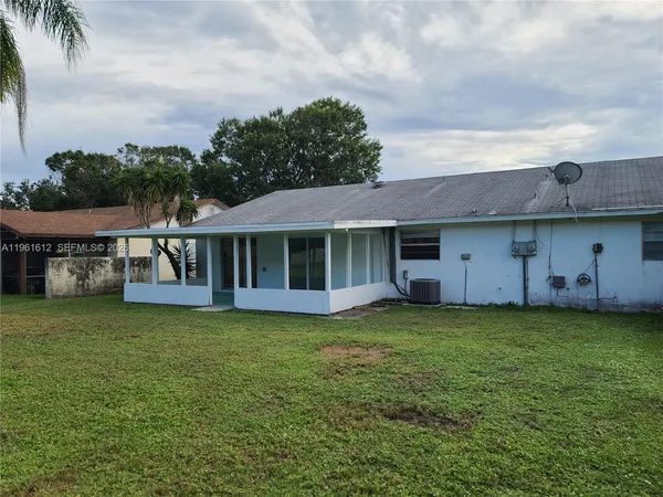a view of a house with a yard and sitting area