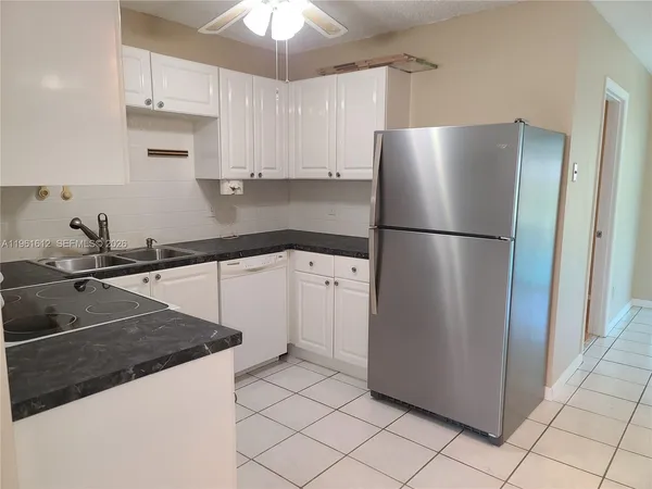a kitchen with a refrigerator a sink and cabinets
