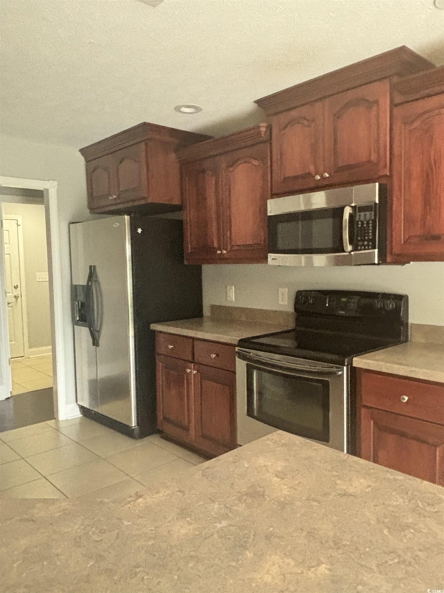 733 Rambler Court Myrtle Beach, SC 29588 - Photo 6 of 10 Kitchen featuring stainless steel appliances, light tile patterned floors, and a textured ceiling