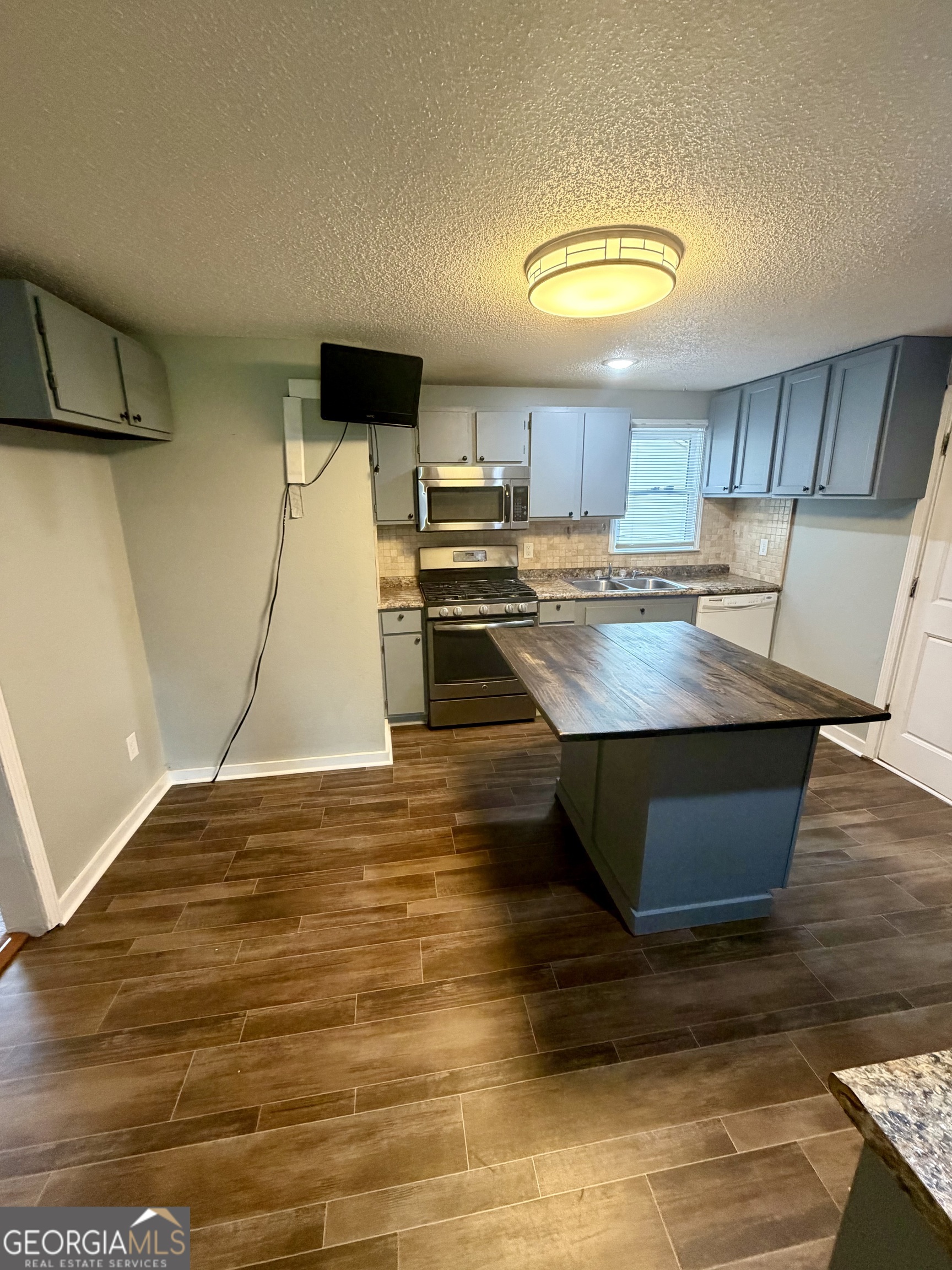 666 Woolfolk Street Macon, GA 31217 - Photo 29 of 60 a kitchen with kitchen island a stove and a sink
