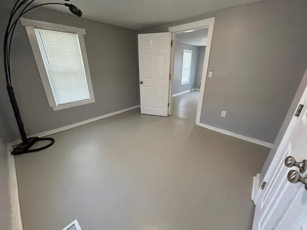 an empty room with windows and closet