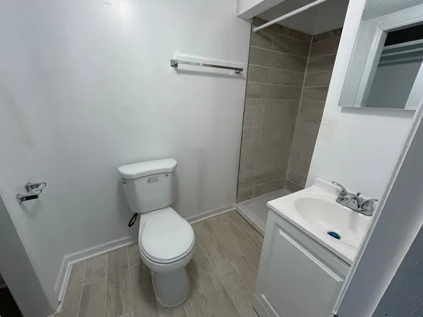 a white toilet sitting next to a white sink and vanity