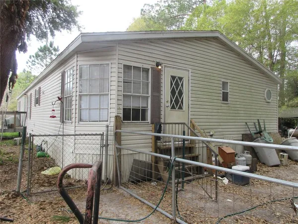 a backyard of a house with table and chairs