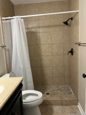 a bathroom with a sink a toilet a shower and a mirror