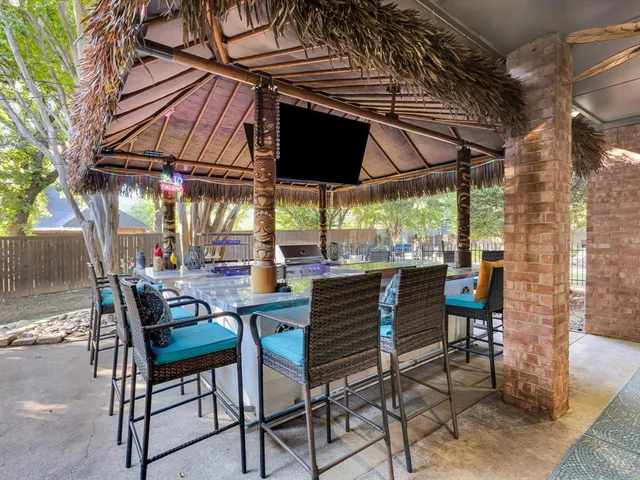 a view of an outdoor space with a table and chairs under an umbrella