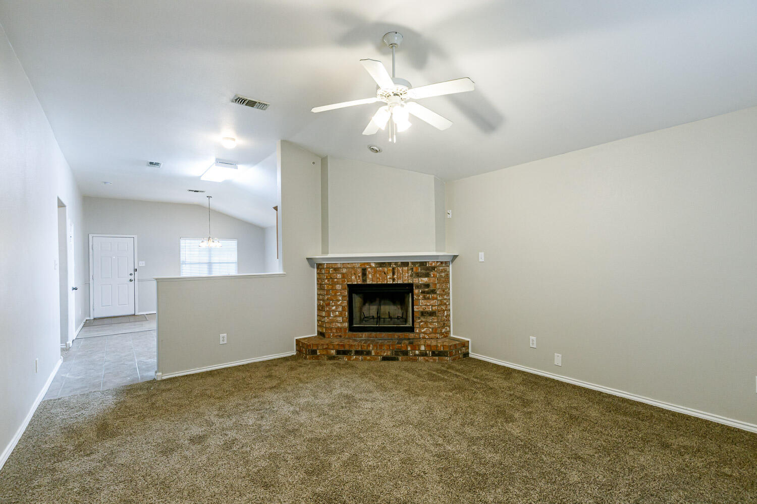 6520 92nd Street Lubbock, TX 79424 - Photo 6 of 30 an empty room with fireplace and fan
