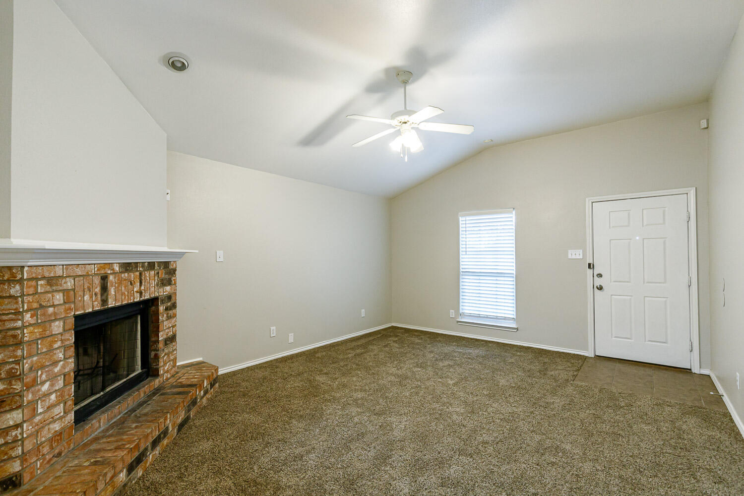 6520 92nd Street Lubbock, TX 79424 - Photo 8 of 30 an empty room with windows fireplace and fan