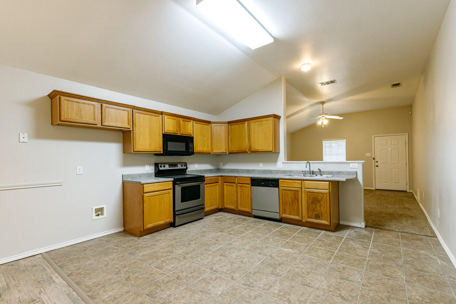 6520 92nd Street Lubbock, TX 79424 - Photo 9 of 30 a large kitchen with granite countertop a sink and a stove top oven