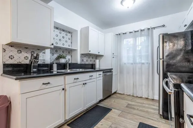 a kitchen with stainless steel appliances granite countertop a refrigerator and a sink