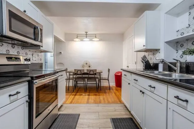 a kitchen with stainless steel appliances granite countertop a stove a sink and a microwave