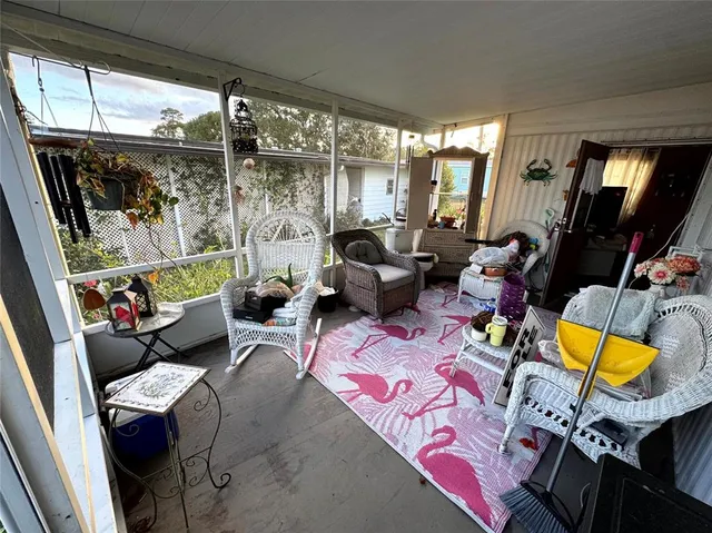 a living room with patio furniture and a floor to ceiling window