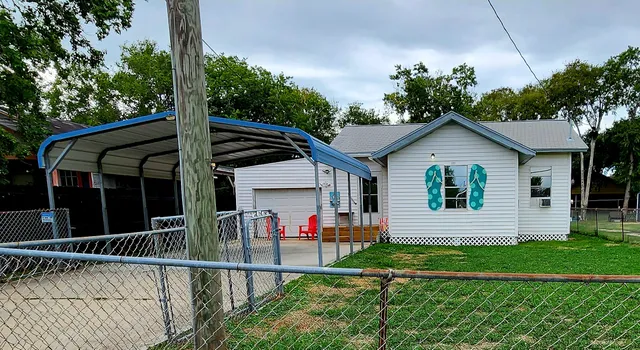 a view of a house with a yard and potted plants