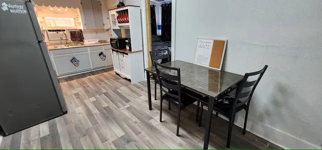 a open kitchen with a wooden floor and furniture