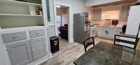 a kitchen with white cabinets and refrigerator