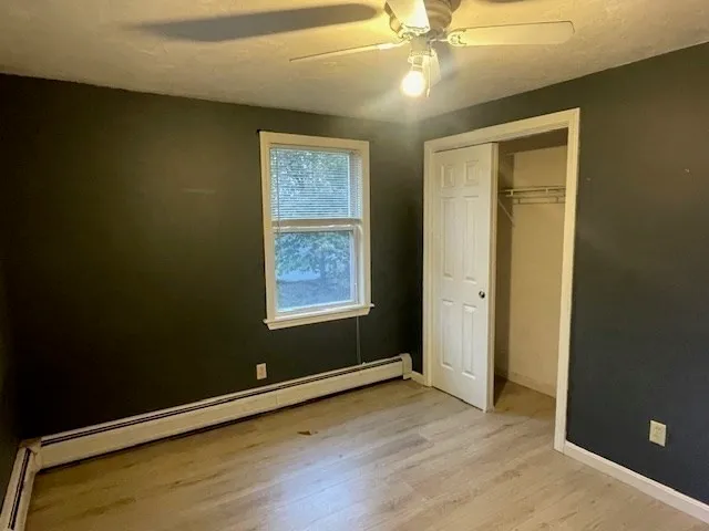 en empty room with window and wooden floor