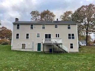 a view of a yard in front of a house with large windows