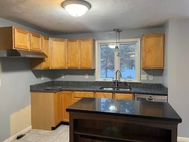 a kitchen with a stove a sink and a window