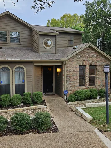 a front view of a house with a yard and potted plants