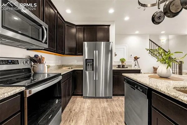 a kitchen with stainless steel appliances granite countertop a sink a stove oven and refrigerator