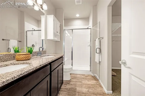 a en suite bathroom with a granite countertop sink and a mirror