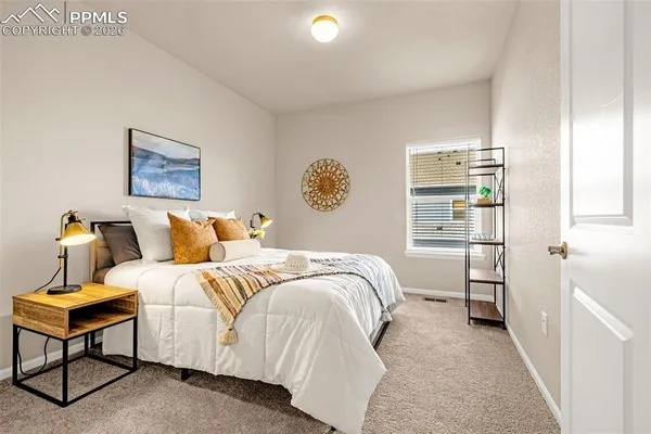 a bedroom with a bed and a painting on the wall