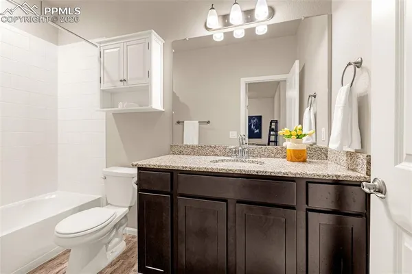 a bathroom with a granite countertop sink toilet and shower