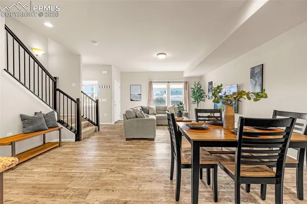 a dining room with furniture and wooden floor