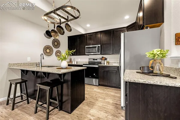 a kitchen with stainless steel appliances granite countertop a sink a stove and a refrigerator