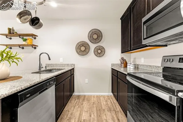 a kitchen with kitchen island granite countertop stainless steel appliances and a sink