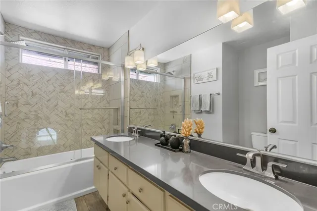 a bathroom with a granite countertop sink mirror and a bath tub