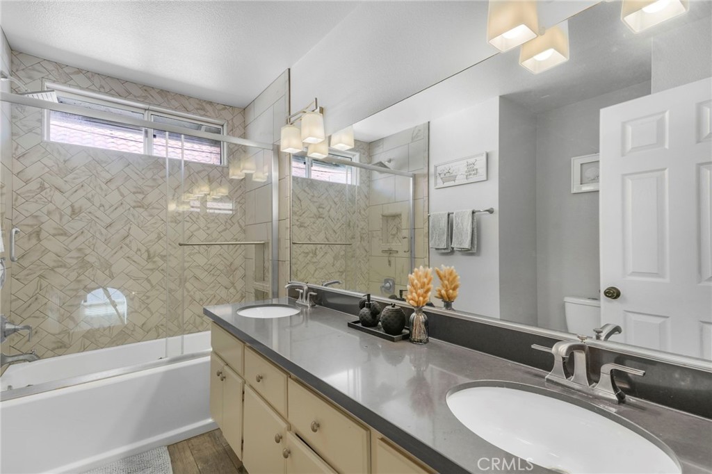 3670 Windstorm Way Riverside, CA 92503 - Photo 20 of 43 a bathroom with a granite countertop sink mirror and a bath tub