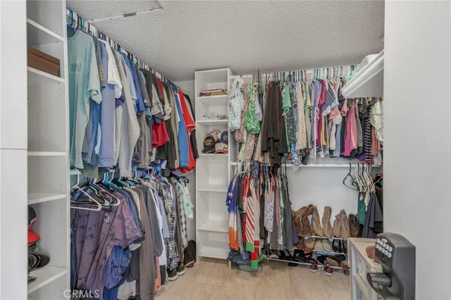 a view of walk in closet with clothes