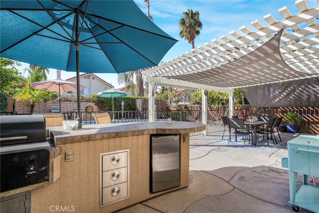 3670 Windstorm Way Riverside, CA 92503 - Photo 26 of 43 a view of a patio with a table and chairs under an umbrella