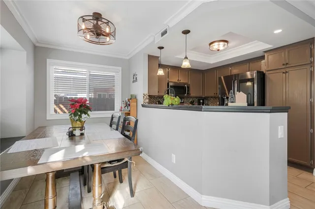 a dining table seating space with stainless steel appliances furniture a chandelier and kitchen view