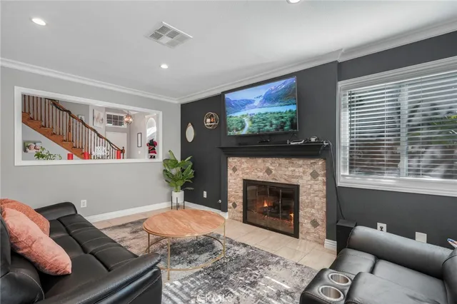 a living room with furniture a flat screen tv and a fireplace