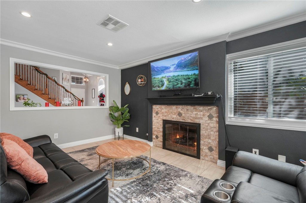 3670 Windstorm Way Riverside, CA 92503 - Photo 9 of 43 a living room with furniture a flat screen tv and a fireplace