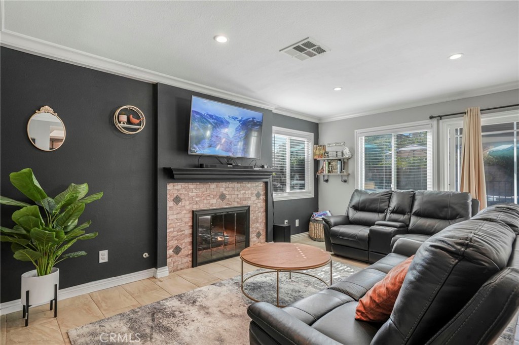 3670 Windstorm Way Riverside, CA 92503 - Photo 10 of 43 a living room with furniture a fireplace and a potted plant