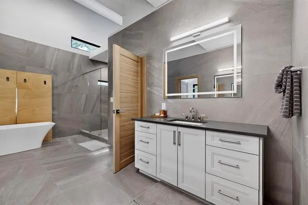 a bath room with a sink a mirror and a bathtub
