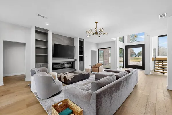 a living room with furniture flat screen tv and wooden floor