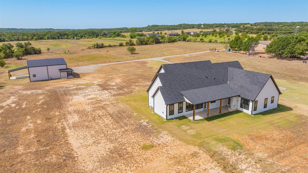 8140 Lavender Road Springtown, TX 76082 - Photo 37 of 40 Modern farmhouse-style residence featuring a dark shingle roof and white vertical siding