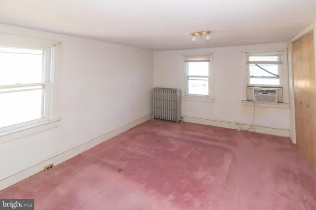 an empty room with windows and closet