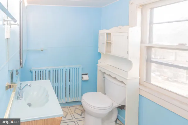 a white toilet sitting next to a bathroom sink
